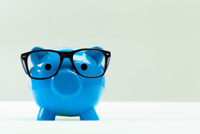 Blue piggy bank wearing glasses